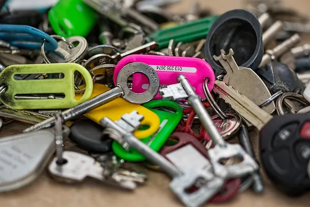 Close-up of a pile of assorted keys with colorful plastic ID tags and a black car remote key fob
