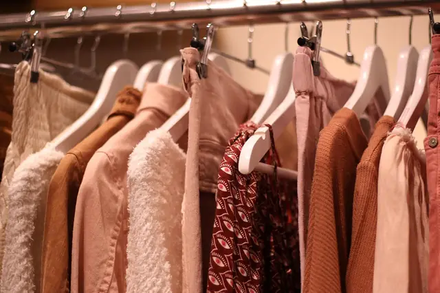 Row of knit sweaters and blouses hanging on a boutique clothing rack
