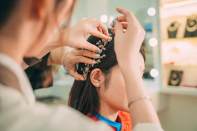 Stylist placing a jeweled hair accessory on a client in a salon
