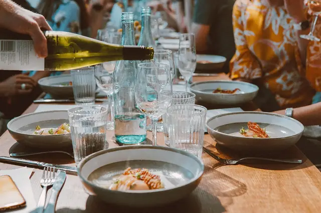 Diners sharing plates and wine at a restaurant table