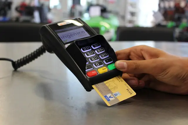 Hand inserting a chip card into a countertop payment terminal
