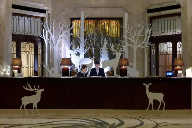 Hotel front desk staff behind a counter with white deer decorations