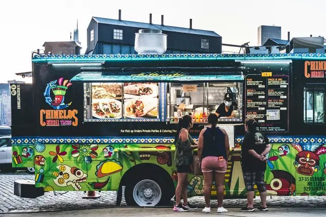 Customers ordering at a brightly painted taco truck