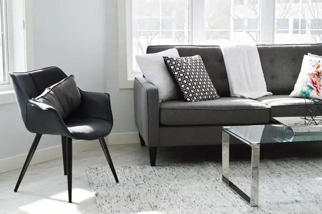 Bright living room with a gray sofa, armchair and glass coffee table
