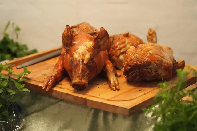Whole roasted pig on a wooden cutting board