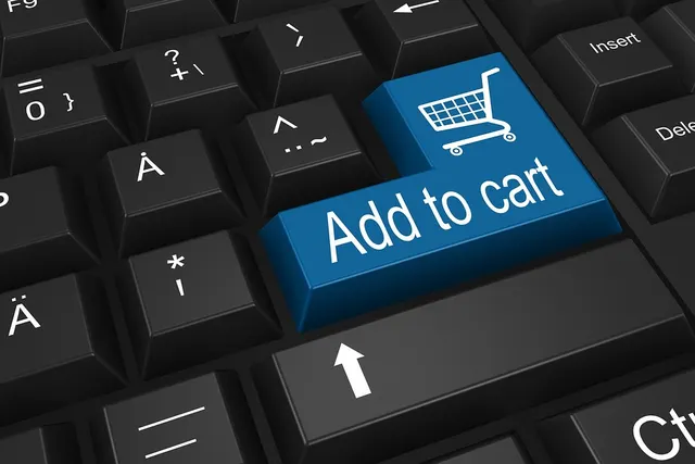 Close-up of a black keyboard with a blue Enter key labeled "Add to cart" with a shopping cart icon
