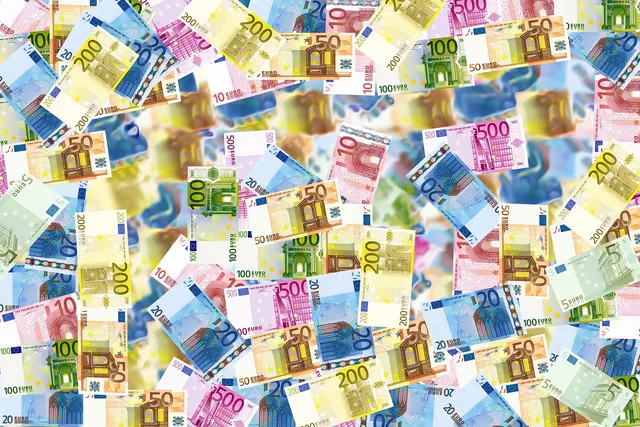 Scattered euro banknotes in 5, 10, 20, 50, 100, 200 and 500 denominations with a blurred center