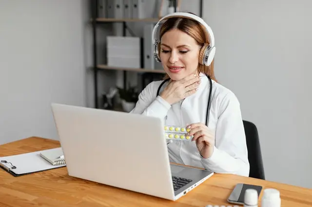 Doctor in a headset on a video call holding a pill pack