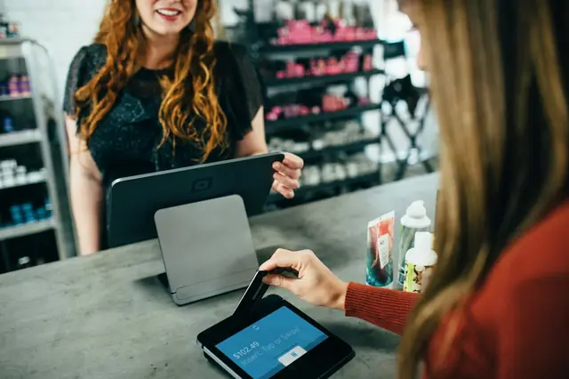 Customer at a counter using a tablet checkout and card reader