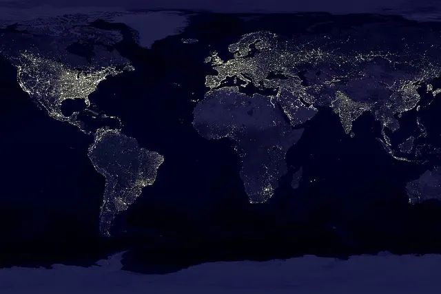 Satellite map of Earth at night showing city lights across North America, Europe, South America and Asia