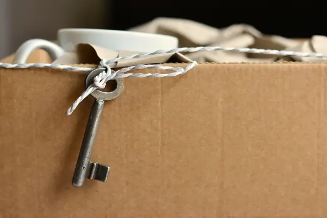 Cardboard moving box with an old key tied by string
