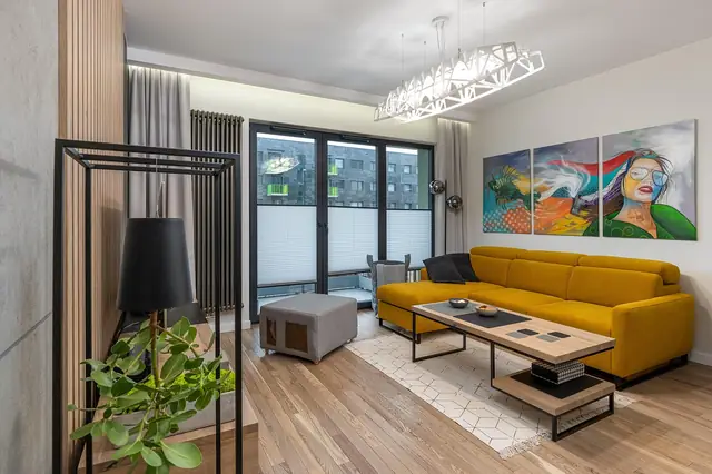 Modern living room with a yellow sofa and colorful wall art