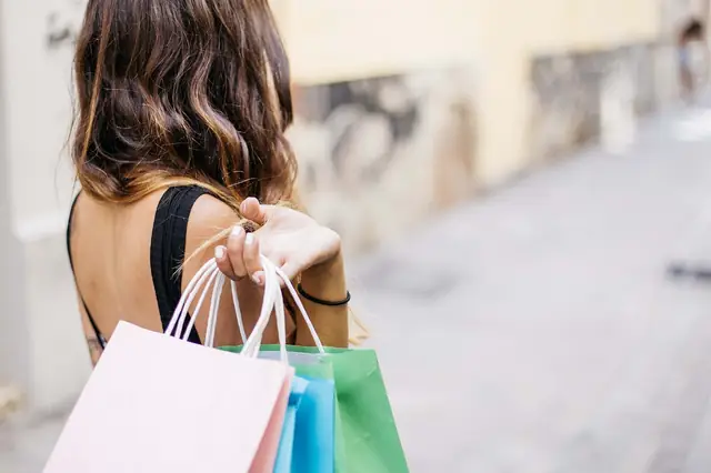 Woman carrying colorful shopping bags over her shoulder