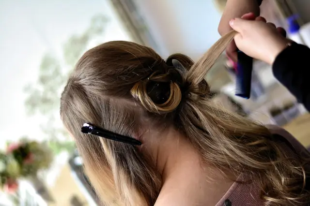 Stylist sectioning and clipping a client's long hair