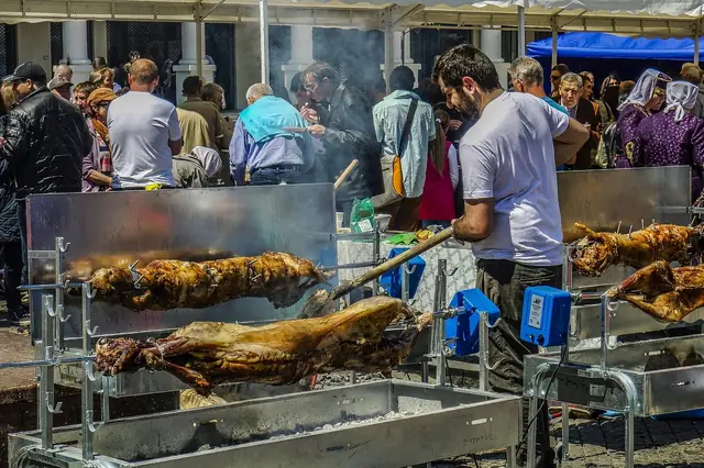 Whole animals roasting on spits as crowds gather at a food festival