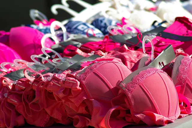 Rows of pink lace bras on plastic hangers stacked on a retail display table at a lingerie stall