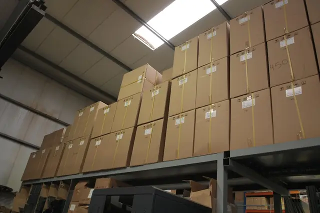 Rows of stacked cardboard boxes on warehouse shelving