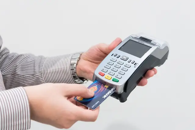 Hand inserting a card into a handheld payment terminal