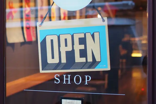 Open sign hanging in a shop's glass door