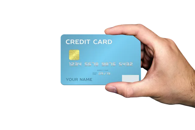 Hand holding a generic light blue chip credit card with a gold EMV chip against a black background