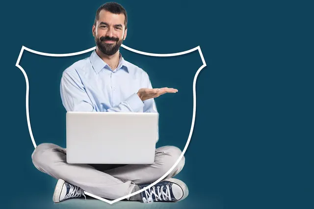 Bearded man in a light blue shirt sits cross-legged with a laptop inside a white shield outline on a teal background