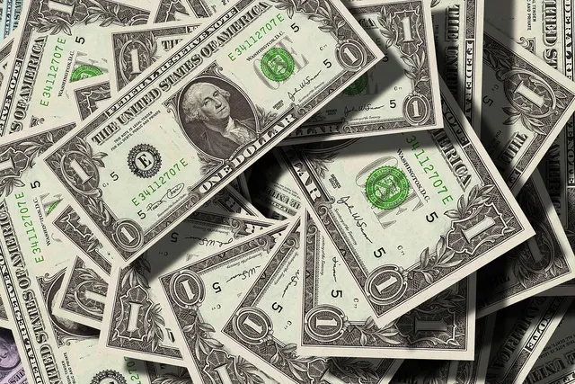 Close-up of a scattered pile of US one-dollar bills overlapping each other, George Washington's portrait visible