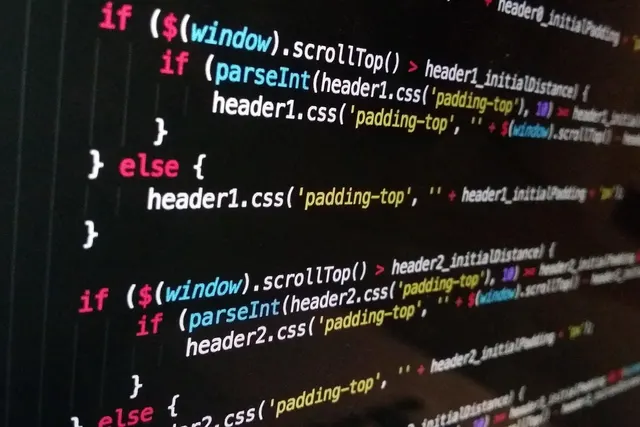 Close-up of a monitor showing syntax-highlighted JavaScript code with jQuery scrollTop and CSS padding rules